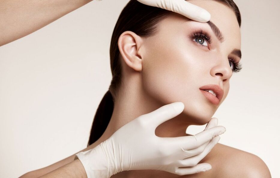 козметологът изследва кожата на лицето преди подмладяване